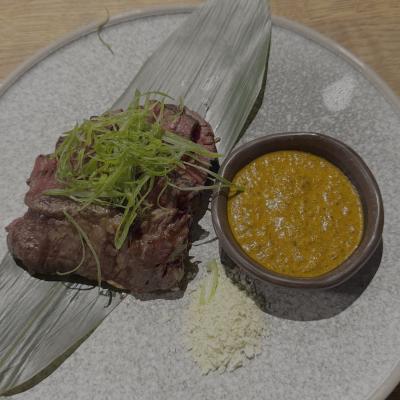 Seared wagyu resting on a banana leaf with spiced miso sauce and daikon