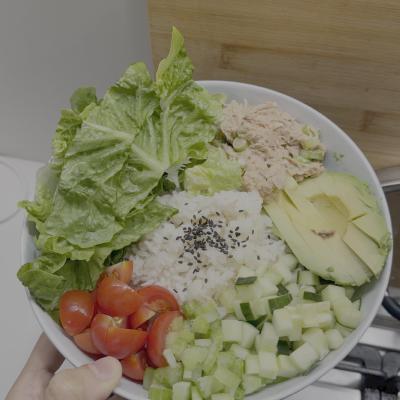 Rice bowl with tuna, avocado, cucumber, cherry tomatoes, and black sesame